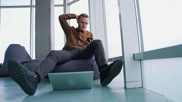 Typing business message. Young modern businessman using smartphone while sitting in the office video