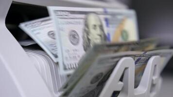 Money counting machine. Banknote counter are counting hundred dollar bills. Close-up video