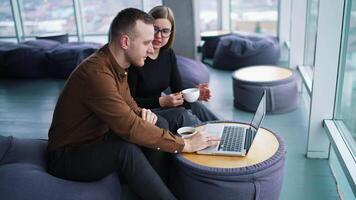 Two smiling creative workers discussing project during meeting in cafe video