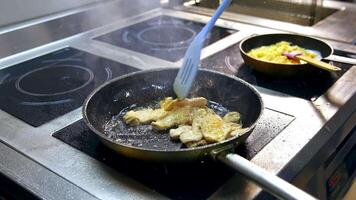 Fillet of sea white fish fried on a pan. Unrecognizible chef mixes dish with spatula. Appetizing and delicious seafood dish. video