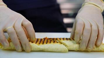 Tasty shawarma with tomatoes, peppers and sauces that make up its composition are laid out on a lacquered table cut in a half. video