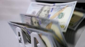 Money counting machine. Banknote counter are counting hundred dollar bills. Close-up video