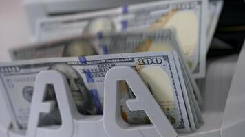 Money counting machine. Banknote counter are counting hundred dollar bills. Close-up video