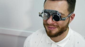Smiling happy male patient in corrective testing glasses. Checking up eyesight in clinic. Handsome patient in ophthalmology. video
