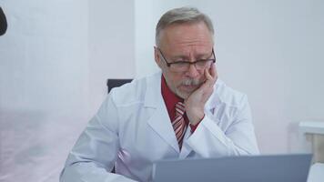 Doctor sitting at his desk and thinking about difficult case he had at work video