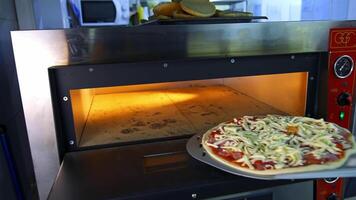Freshly Prepared Pizza on a Wooden Table in a Cafe. Appetizing hot pizza close-up on the background of the interior of a modern restaurant. video