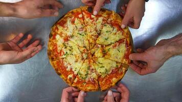 Freshly prepared pizza on a stainless steel table in a cafe kitchen. Appetizing hot pizza with cheese, bacon and greens on the top. video