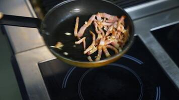 Cooking bacon for breakfast. Chef turns crispy bacon in frying pan. Ingredients for burger. Close up. video