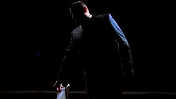 Actor man on a stage. Dark silhouette of a man wearing suit performing on a scene in theatre at spotlight. View from the stage. video