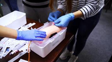 Doctor in gloves making injection with a syringe for puncture. Simulation medical training model. Medical procedure concept, simulation medicine training. video