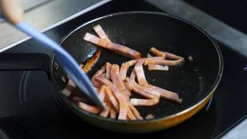 Chef cooking breakfast. Turning an amazing crispy bacon, rich in fat and colour. Sizzling and smoking in a hot pan. video