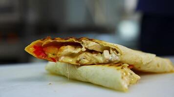 Tasty pita roll with vegetables and meat poured with red souce. Tasty fast food prepared in restaurant. video