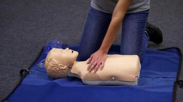 CPR training medical procedure. Demonstrating chest compressions on CPR doll in the class. from medical courses video