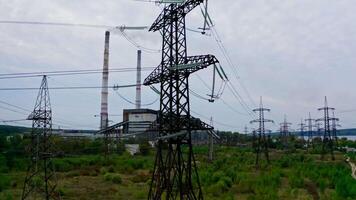 Electricity pylons and high-voltage power lines on the green grass. Power plant. Electrical power grid. View from the top. video