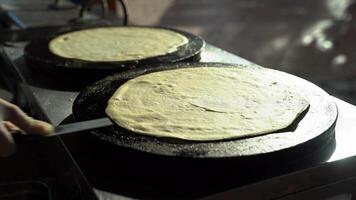 Making thin pancakes by flipping and frying them on the stovetop video