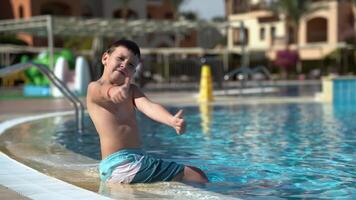 The boy is very happy sitting near the pool video