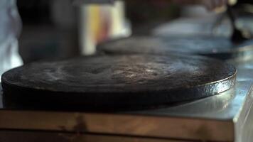 Flatbreads are prepared on the stove and spread with a special wooden stick. video