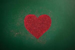 Red sparkle heart on green background photo