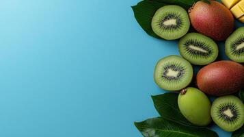 Fresh kiwi fruit slices and mango chunks on a blue background photo
