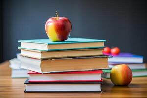 stack of books with apples on a desk photo
