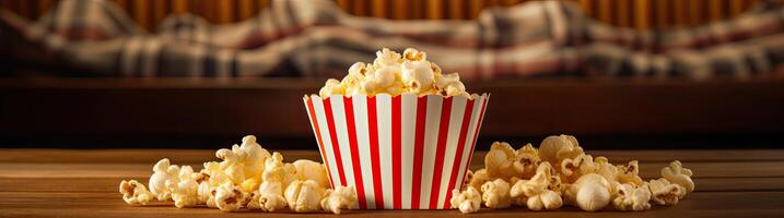 Delicious popcorn in a striped box on a wooden table photo