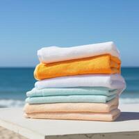 stack of colorful beach towels on wooden table photo