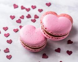 heart shaped macarons on a gray background with scattered heart confetti photo