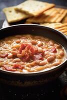 Hearty bean and bacon soup in a bowl with toasted bread photo