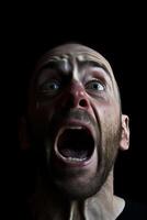 intenso facial expresión de un hombre gritos en el oscuro foto