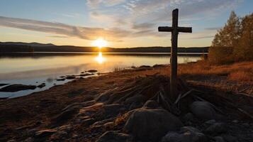 Serene sunset over a tranquil lake with a wooden cross photo