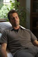 man relaxing on couch with eyes closed photo
