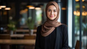 Confident young woman in hijab smiling in cafe photo