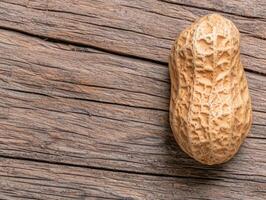 Single peanut in shell on rustic wooden background photo