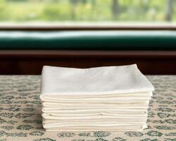 Stack of white napkins on a patterned table photo