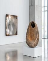 Modern art gallery interior with abstract metal sculpture and stone sculpture on white pedestal photo