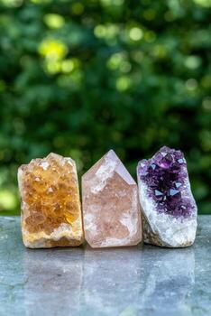 Tres vibrante cristales amatista, Rosa cuarzo, y citrino, arreglado en un reflexivo superficie foto