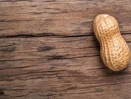 Single peanut in shell on rustic wooden background photo