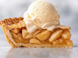 A slice of warm apple pie topped with a scoop of vanilla ice cream photo