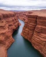Aerial view of a stunning red rock canyon with a deep blue river flowing through it photo