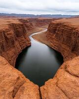Aerial view of a winding river cutting through a deep canyon in a desert landscape photo