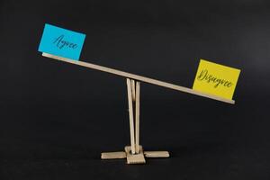concept of duality using sticky notes with the antonym words Agree - Disagree made by hand on a dark background photo