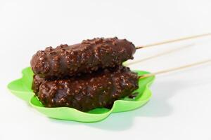 Chocolate ice creams on green plate isolated on white background photo