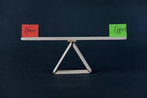 concept of duality using sticky notes with the motivational words Effort - Dare made by hand on a dark background photo