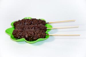 Chocolate ice creams on green plate isolated on white background photo