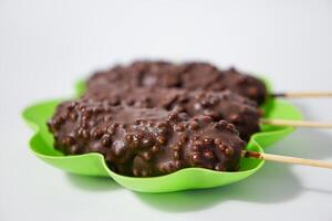 Chocolate ice creams on green plate isolated on white background photo