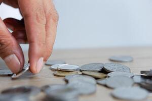 A man's hand picks up coins from the scattered coins photo