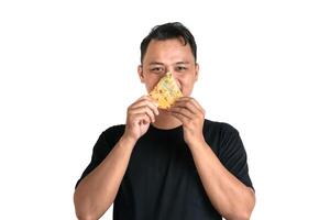 A man in a black shirt smiles while holding a flavorful slice of food photo