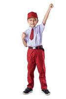 A Indonesian boy in a red school uniform, raising his fist in celebration with a big smile on his face. photo