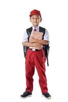 A Indonesian kid student in red and white uniform with a backpack, holding books and looking confident. photo