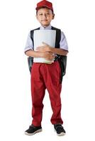 A Indonesian kid student in red and white uniform with a backpack, holding books and looking confident. photo